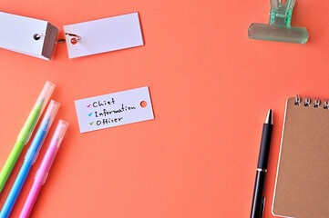 There is word card with the word chief information officer on the desk.