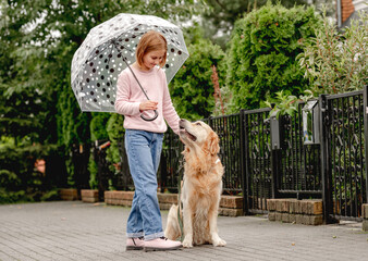 Preteen girl with golden retriever dog