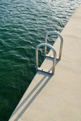 Handrails of a metal seawall ladder at the bay in Miami, Florida