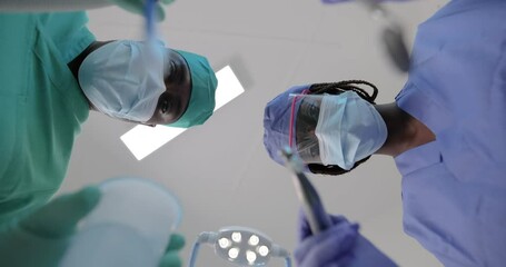An African dentist and her assistant during a visit, point of view of the client's mouth.