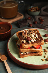 Tasty toasts with chocolate spread, nuts, strawberries and banana served on wooden table