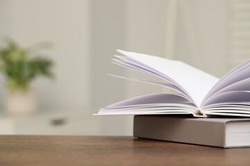 Stack of hardcover books on wooden table indoors. Space for text