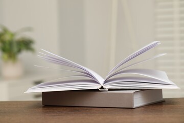 Stack of hardcover books on wooden table indoors