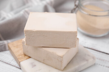 Blocks of compressed yeast on white wooden table, closeup