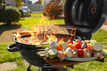 Skewers with meat and vegetables near barbecue grill outdoors