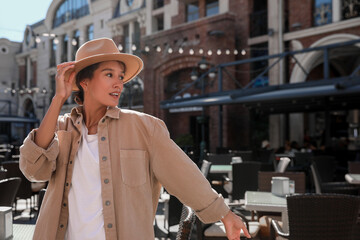 Fototapeta premium Portrait of happy young woman on city street