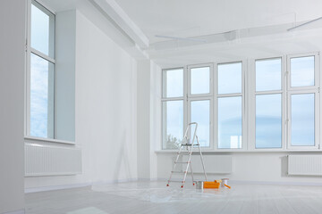 Stepladder and painting tools near window in empty room, space for text