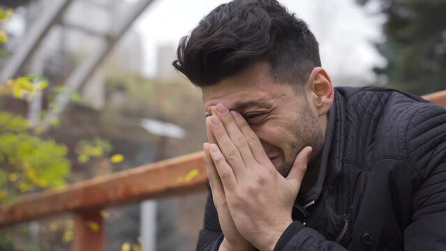 Sadness, loneliness. The young man is crying outdoors and his nerves are broken.
The sad man sitting outdoors is crying, the concept of family problems, depression and suicide.
