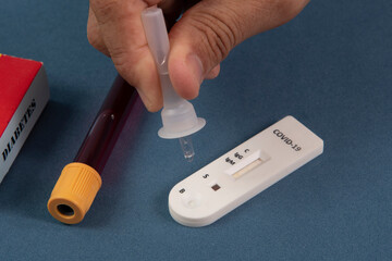 Covid-19 rapid test with person dripping the reagent