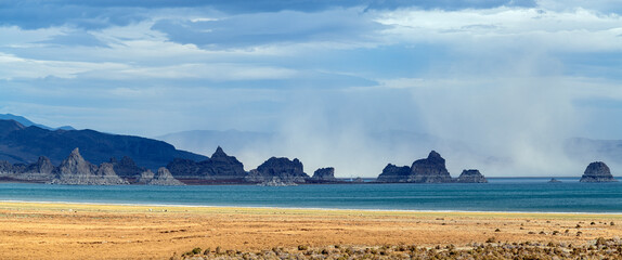 Panorama of a dust storm blowing across the rock formation in Pyramid Lake, Nevada, USA