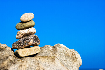 Fototapeta na wymiar Selective background. Pyramid of stones on the sea. Zen.