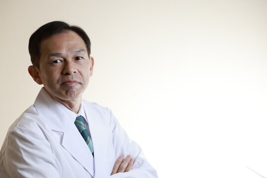 Middle-aged Asian doctor in a white coat on white background. Concept image of regenerative medicine, vaccine development and advanced therapy.