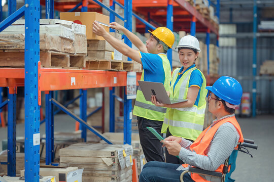 The supervisor is handicapped with a wheelchair inspecting the work background in warehouse.logistic  business export ,Warehouse worker checking packages on store