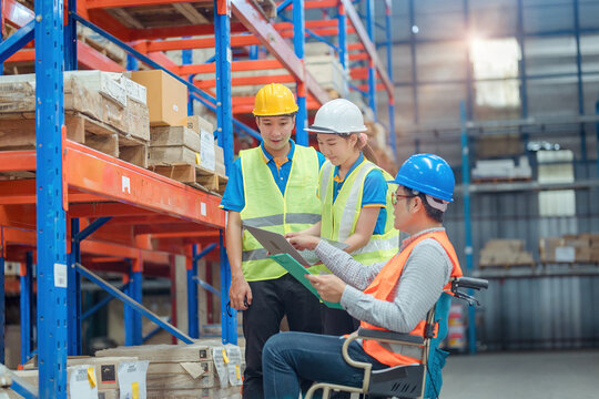 The supervisor is handicapped with a wheelchair inspecting the work background in warehouse.logistic  business export ,Warehouse worker checking packages on store
