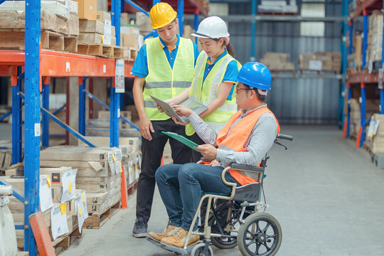 The supervisor is handicapped with a wheelchair inspecting the work background in warehouse.logistic  business export ,Warehouse worker checking packages on store - Powered by Adobe