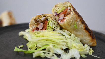 Burrito with grilled chicken and vegetables (fajitas, pita bread, shawarma) on the stove. Close up