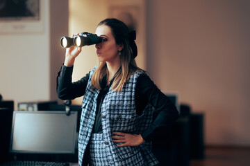 Businesswoman Looking through a Pair of Binoculars in the Office. Visionary manager seeking for...