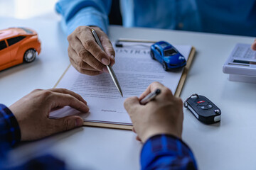 Selling a car. Management concept. The dealer gives the car keys to the new owner or renter with a contract of insurance. Customers who sign the contract and terms of the document agreement.