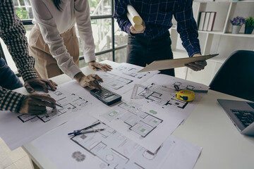 
Engineering team meeting for colleagues discussing and reviewing blueprints at desk in office...