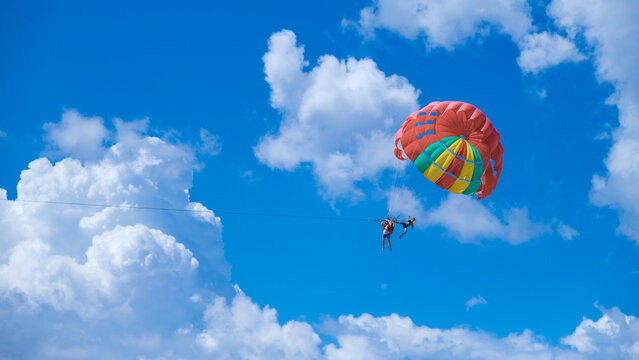Parachute in the sky at the beach of Kata Phuket. bright blue sky with a parachute