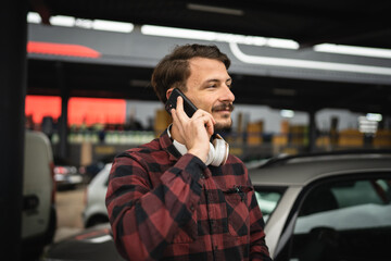 one man use mobile phone talk make a call at parking lot alone in day