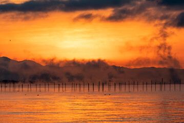 琵琶湖の夜明け　冬を告げる大きな気嵐　幻想的な朝焼けの風景　滋賀県大津市　湖西の和邇浜