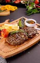 Grilled beef steak on wooden board.