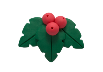 Holly berry with leaves made of plasticine. Gingerbread cookie in the shape of a holly berry with leaves, handmade with plasticine. Christmas greeting card concept