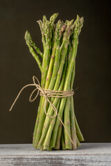 A bunch of fresh green asparagus on a dark background