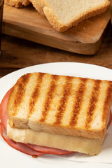 Delicious mortadella and cheese toasted bread on plate. Selective focus.