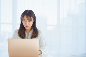 PCを見て困った表情をする女性