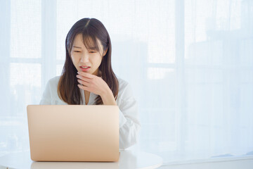 パソコンを見て嫌な表情をする女性
