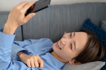 Obraz na płótnie Canvas 笑顔でスマートフォンを眺める女性