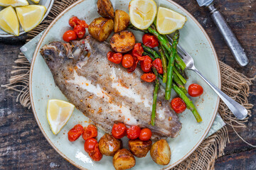 Lemon sole baked with potatoes, baby tomatoes and asparagus