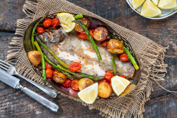 Lemon sole baked with potatoes, baby tomatoes and asparagus