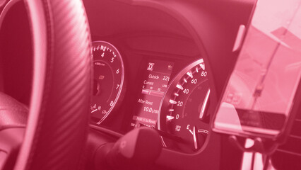 Color of year 2023 Viva Magenta. Image with speedometer dashboard is toned in pantone color of viva magenta. New Fashion colour. Speedometer and steering wheel of a modern car in a sun flare. - Powered by Adobe