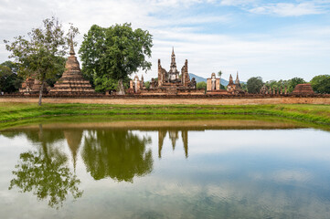 Fototapeta na wymiar Scenery view of Wat Mahathat temple the most important and impressive temple compound in Sukhothai Historical Park in Sukhothai province of Thailand.