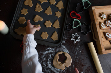 The child rolls out the dough for gingerbread . Merry Christmas and happy holidays. Family cooking of festive food. Christmas pastries