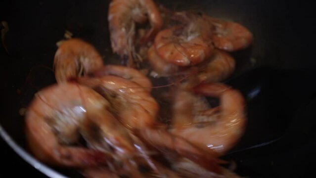 shrimps are fried in a frying pan with garlic