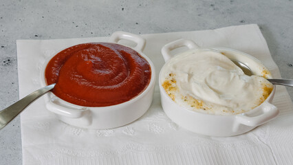 Ketchup in a bowl, and Greek yogurt garlic dipping sauce close-up on the kitchen table