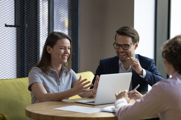 Office employees friendly colleagues laughing during briefing, informal meeting, take part in group seminar in modern workspace, enjoy pleasant communication, share creative ideas, engaged in teamwork