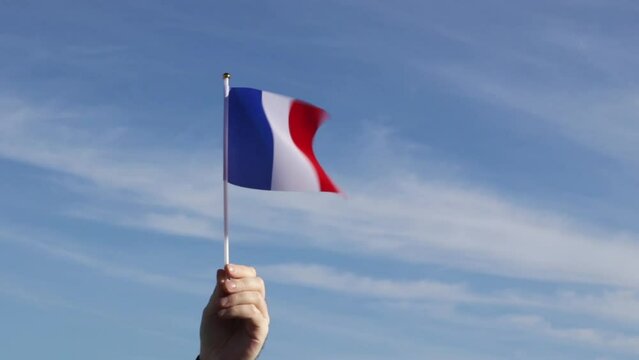french flag in hand flutters in the wind against the sky, independence national day of france, country freedom, patriotism, Public Holiday, patriotic festival
