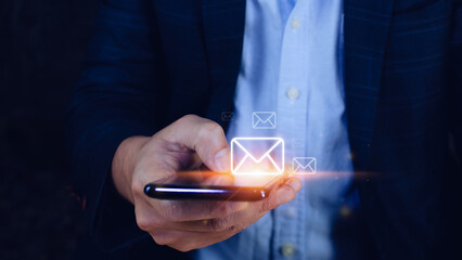 Businessman holding touching mobile phone and checking email online with virtual interface technology.Direct marketing, online message, E-mail, electronic mail,communication concept.