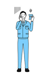 預金通帳を見て落ち込む作業着を着た男性（経営者、管理職、工場長）