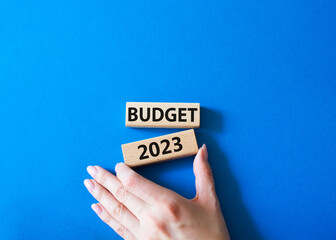 Budget 2023 symbol. Wooden blocks with words Budget 2023. Beautiful blue background. Businessman hand. Business and Budget 2023 concept. Copy space.