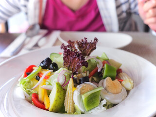 a person about to enjoy a colorful, nutritious, light, low calorie plate of salad.
