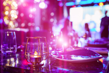 Served table of a night club against the background of multi-colored lights