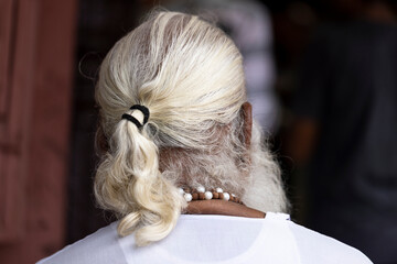 Long white hair pulled back in a ponytail. Old indian man.