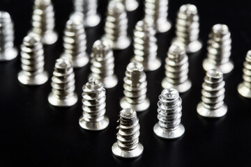 A group of Small bolts for computer equipment and computer assembly on black background