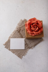 Brown paper present box, fabric rose flower, blank postcard on white background. Valentines day, birthday or wedding surprise